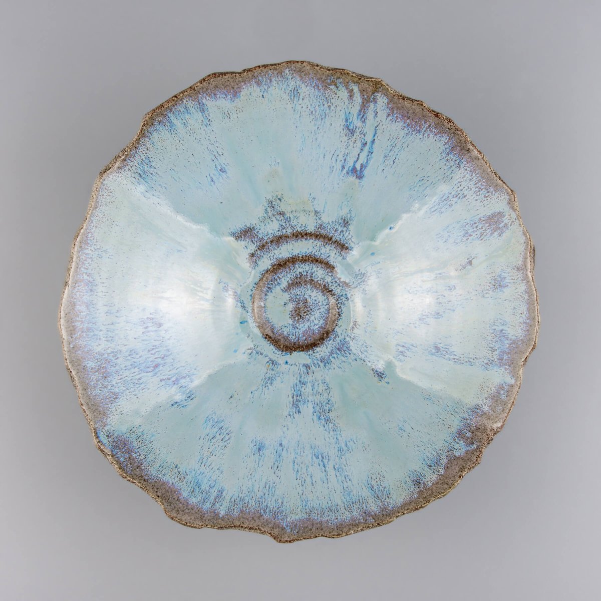 Top-down view of artisan stoneware bowl showing spiral detail and glossy blue finish.