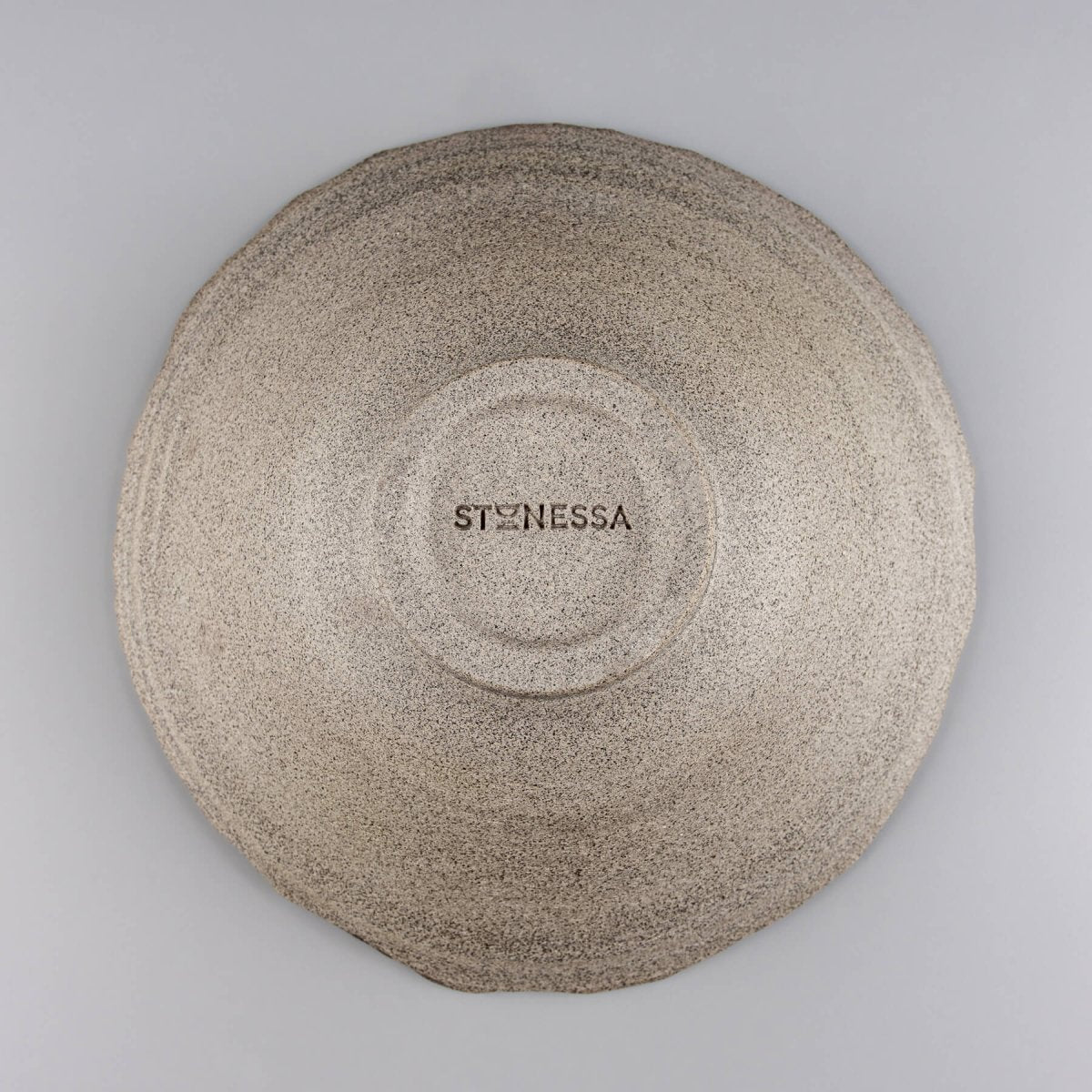Underside view of handmade bowl showing unglazed surface and foot ring.