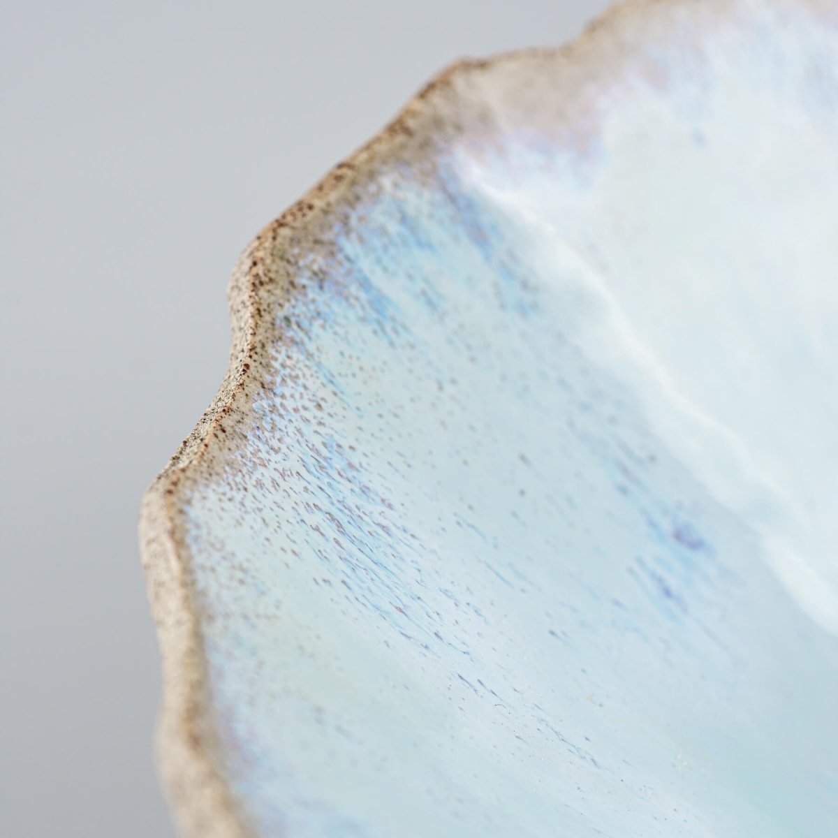 Flat lay showing the wide rim and inner spiral design of handmade ceramic dish.