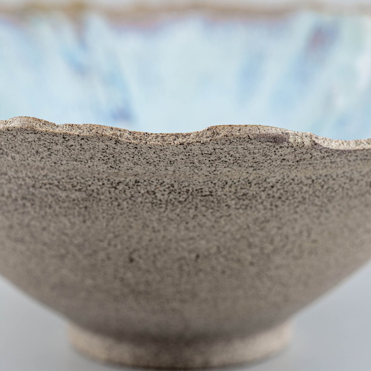 Close-up of handmade stoneware bowl’s interior showcasing blue glaze transitions.