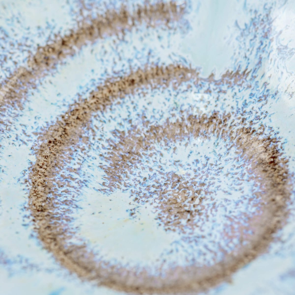 Macro shot of inner glaze finish with spiral imprint and smooth ceramic surface.