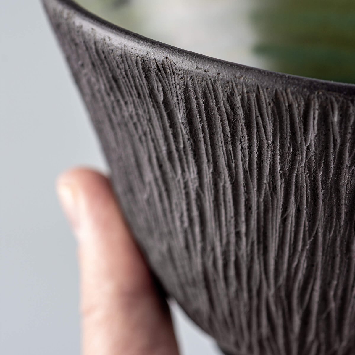Textured dark stoneware surface of handmade ceramic bowl for home or boutique hotel use.