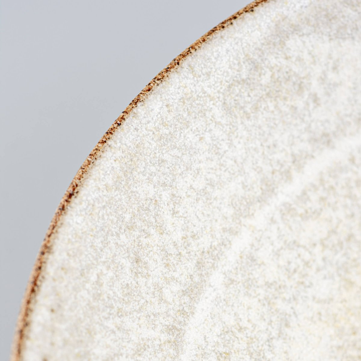 Close-up of rim detailing on handmade ceramic bowl with tactile stoneware texture.