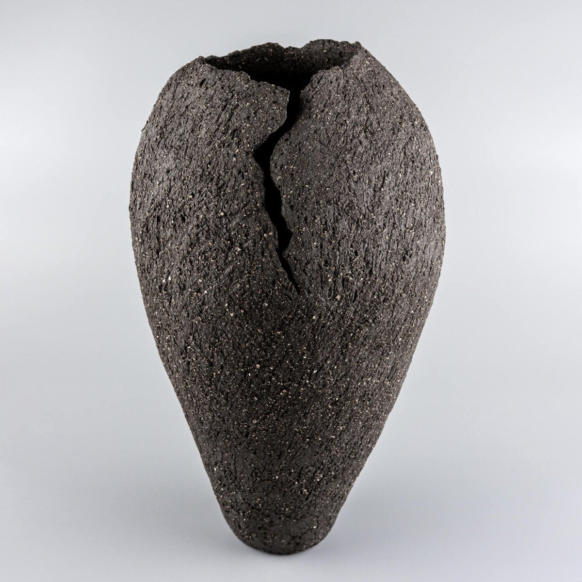 Handmade ceramic vases with dark stoneware clay and sculptural crack design for luxury interiors.