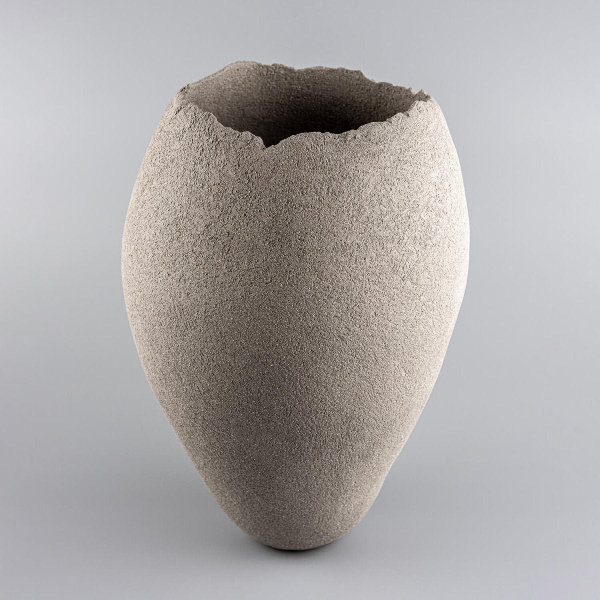 Handmade vases in sculptural gray stoneware clay with a natural textured surface.