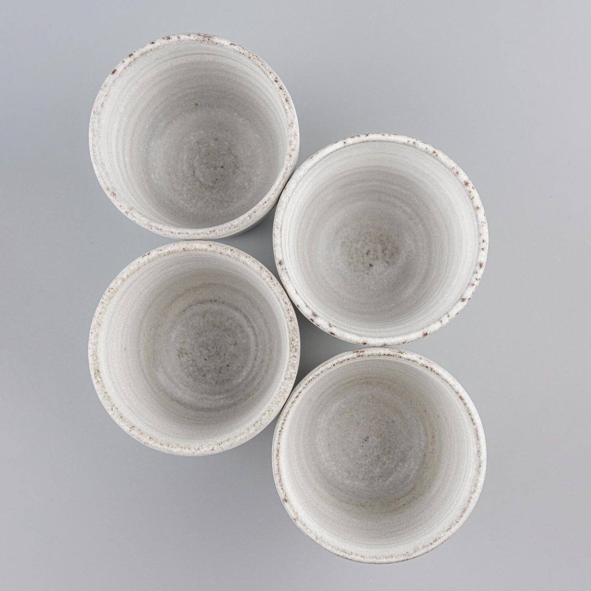 Set of handmade ceramic mugs with white matte glaze for coffee, tea, and home interiors.