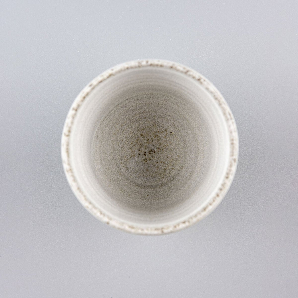 Artisanal pottery cup set combining rustic dark glaze and refined white finish for boutique hotels.