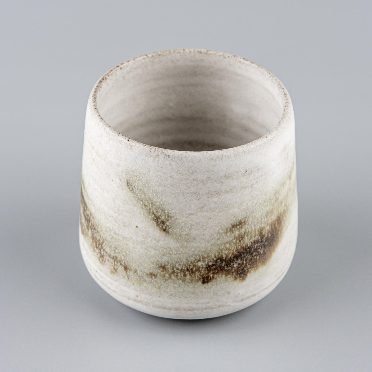 Top view of a handmade ceramic espresso cup with a unique glaze, perfect kitchenware for coffee lovers.