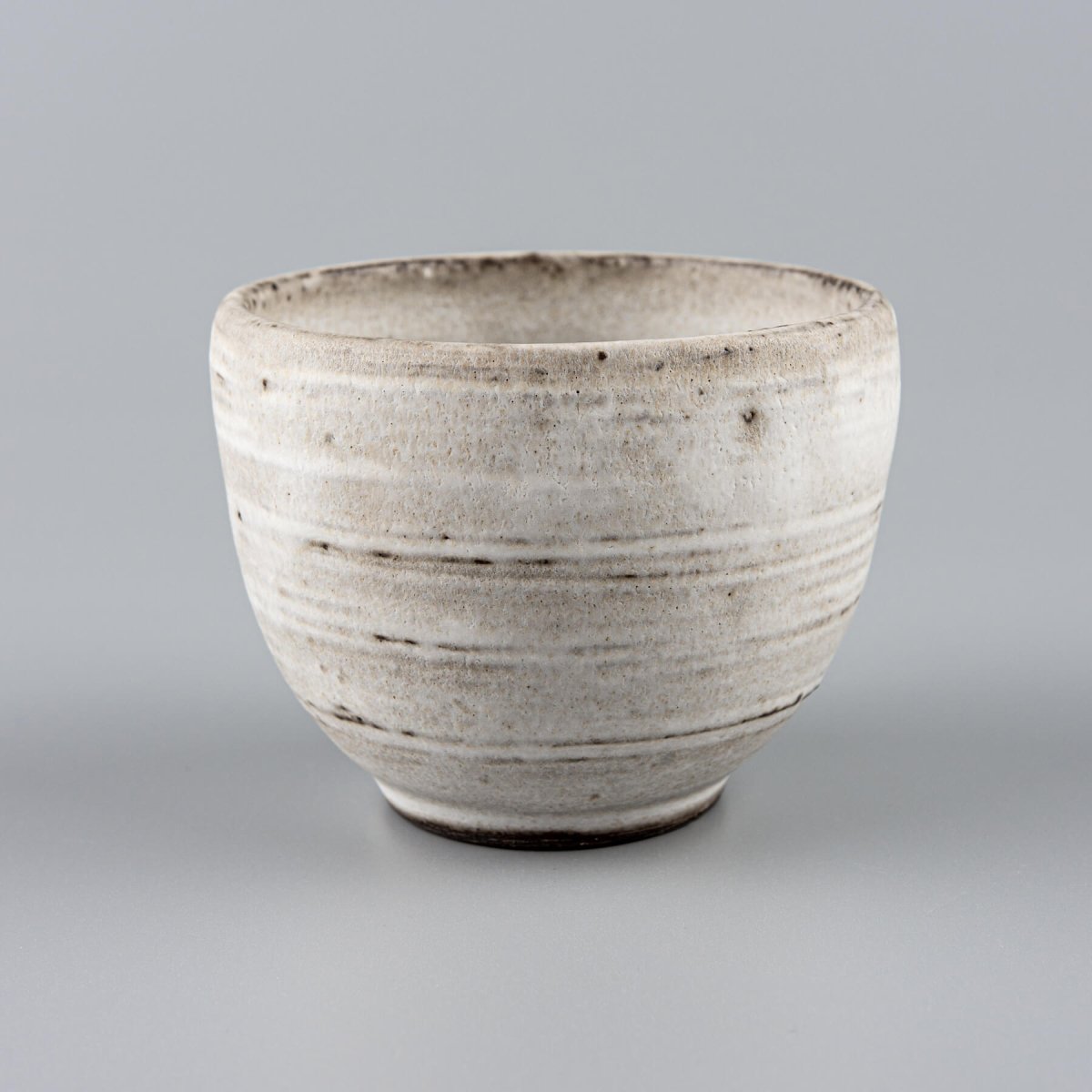 Minimalist ceramic coffee mugs with curved edges and a flat base, ideal for boutique hotels and fine dining restaurants.