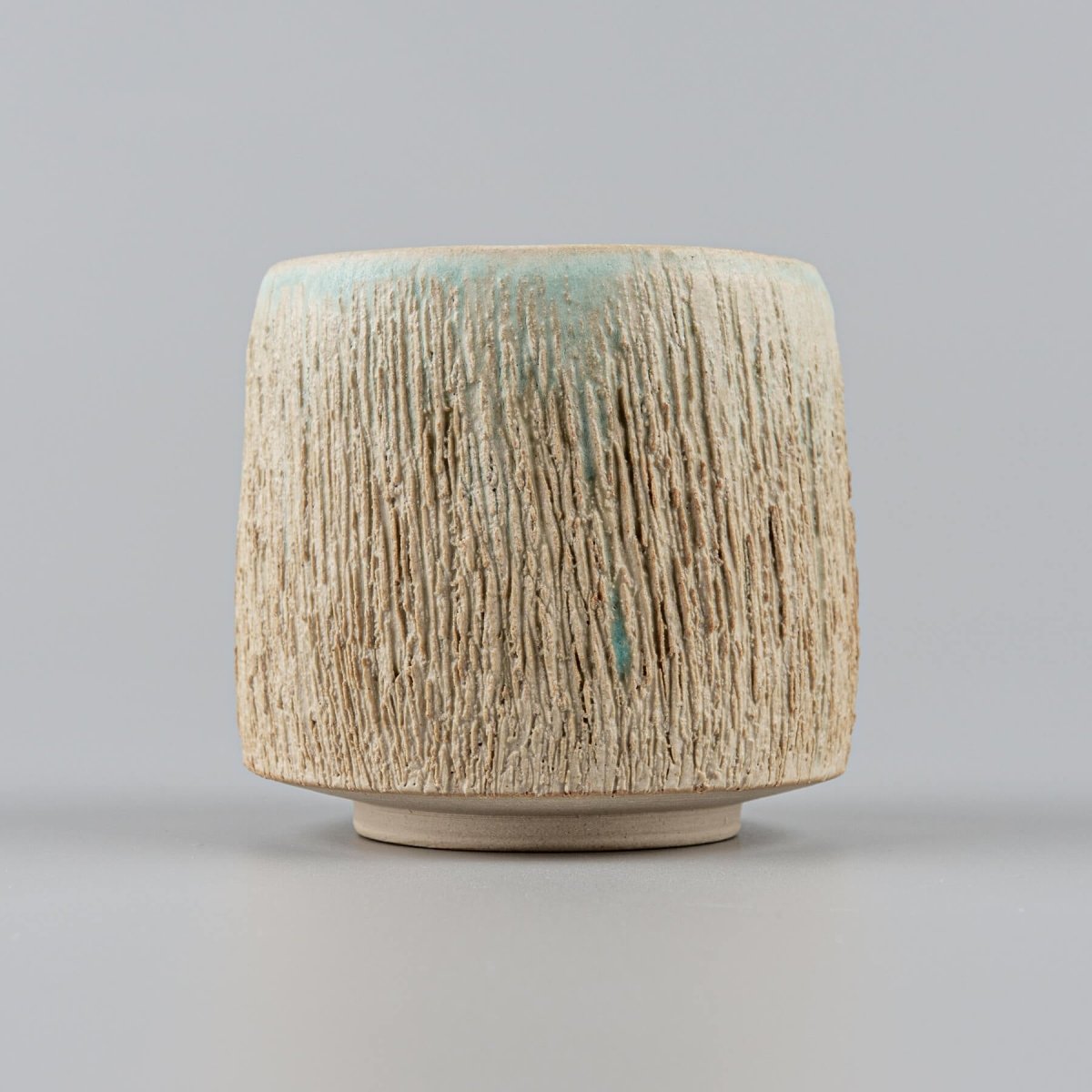 Pottery mugs with textured exterior and aqua-glazed interior for fine dining and home decor.