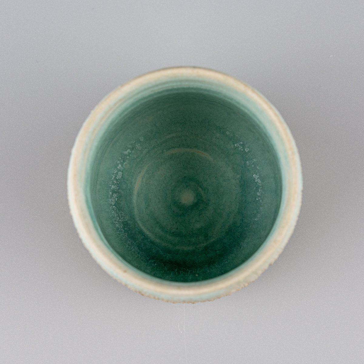 Top view of aqua glazed ceramic mug, handmade pottery for fine dining and culinary use.