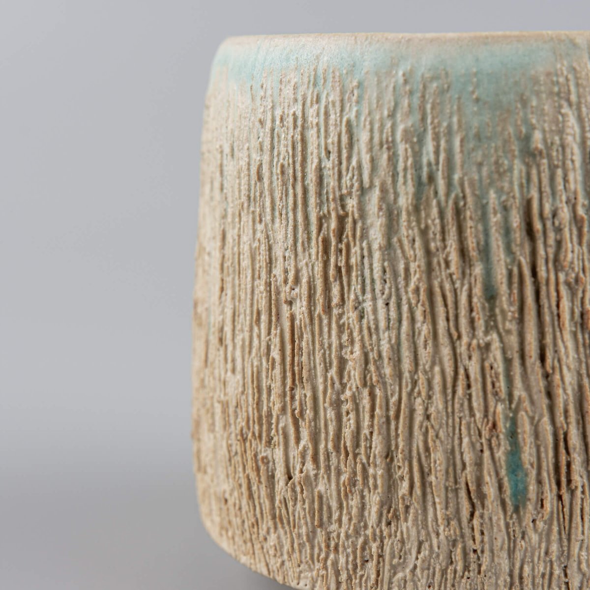 Side view of aqua glazed pottery mug, handmade design for boutique hotels and interior design.
