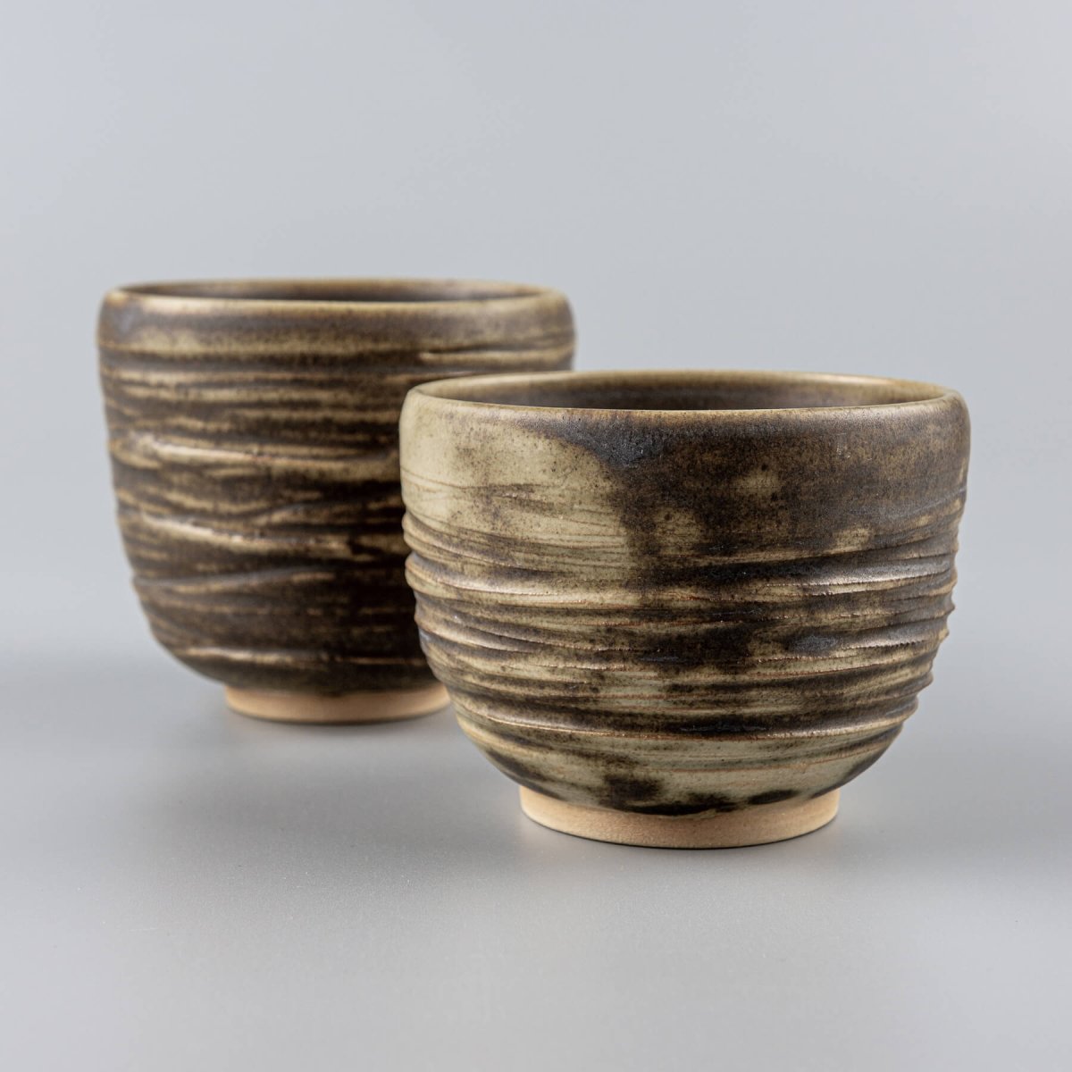 Handmade ceramic mugs with textured carving and olive-green glaze, ideal for home, boutique hotel, and fine dining tableware.
