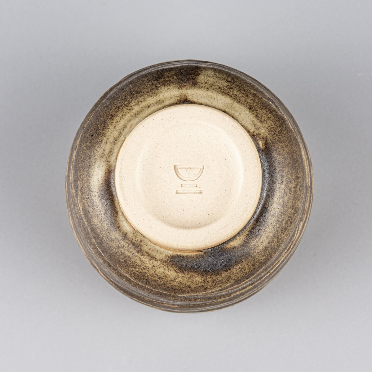 Base of ceramic mug with smooth finish, highlighting handmade craftsmanship and collectible pottery design.