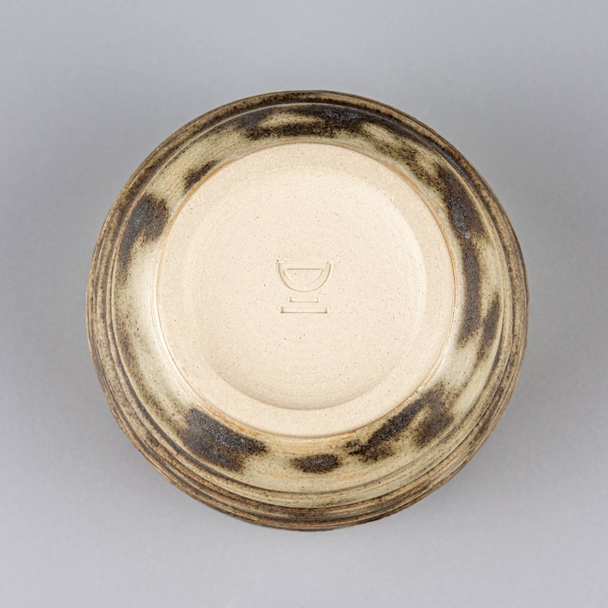 Underside of handmade ceramic mug with olive glaze details, perfect for kitchenware and interior styling.