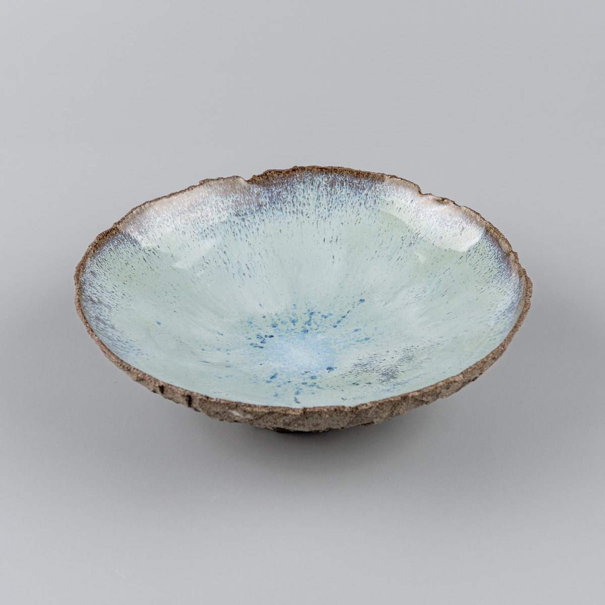 Detail of glossy blue glaze blending in ceramic bowl interior.