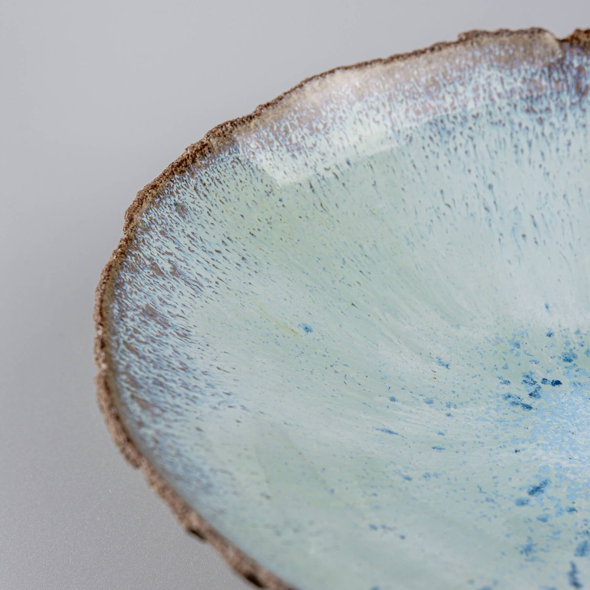 Close-up of handcrafted blue glazed surface with artistic texture.