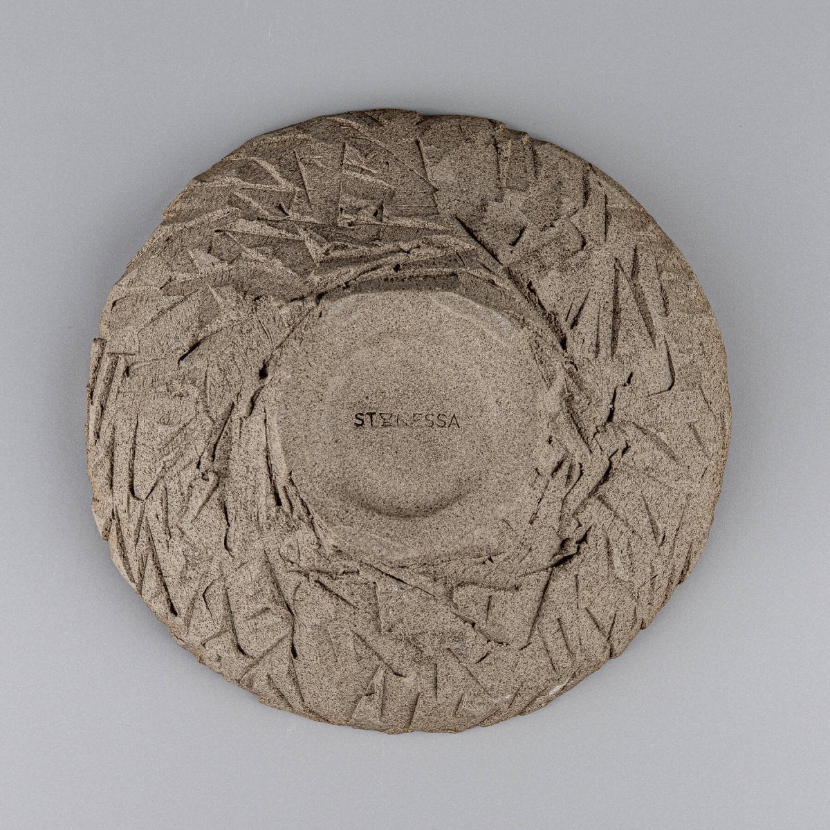 Underside of artisan bowl revealing carved base and natural clay.
