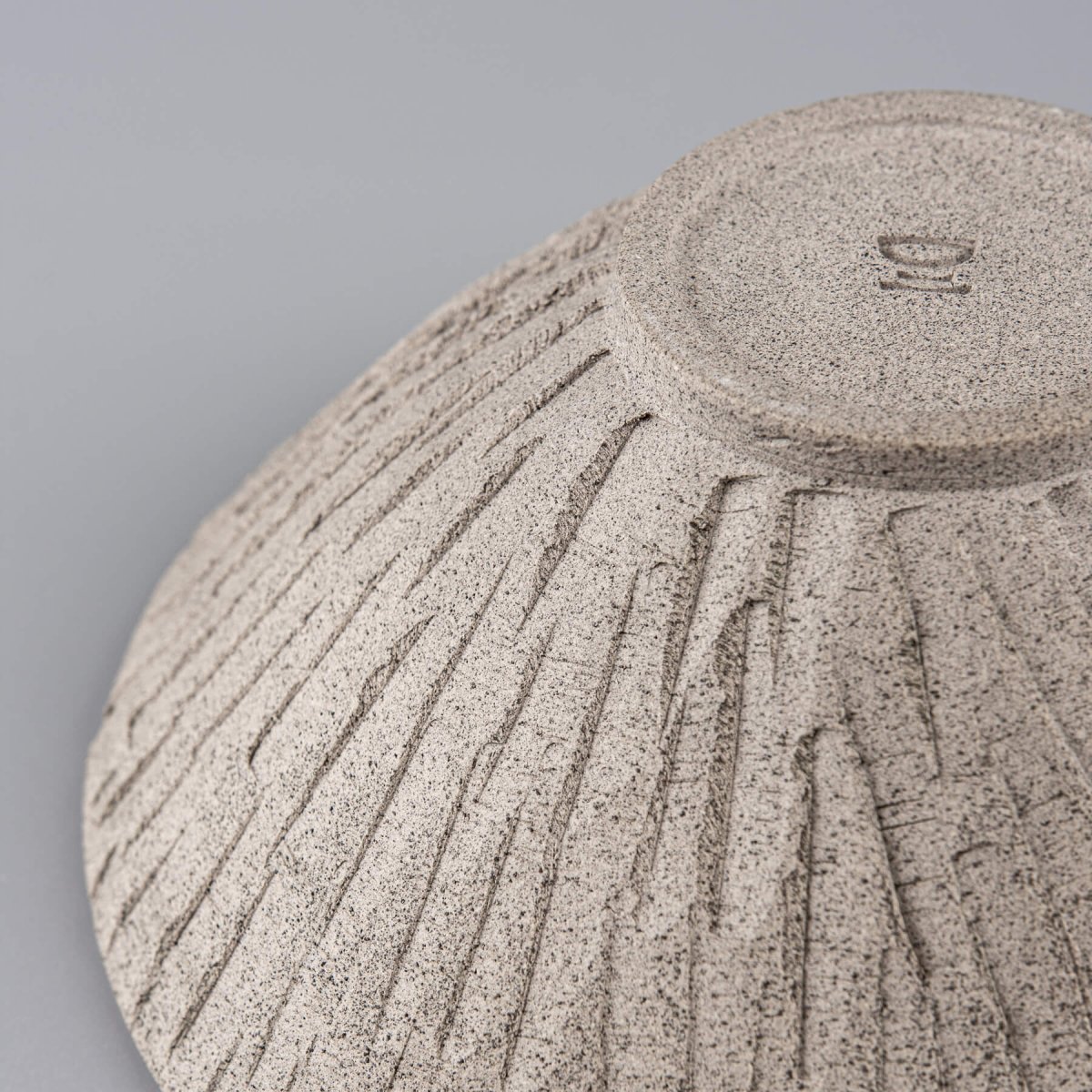 Detail of carved lines on stoneware bowl emphasizing handmade craftsmanship and decor purpose.