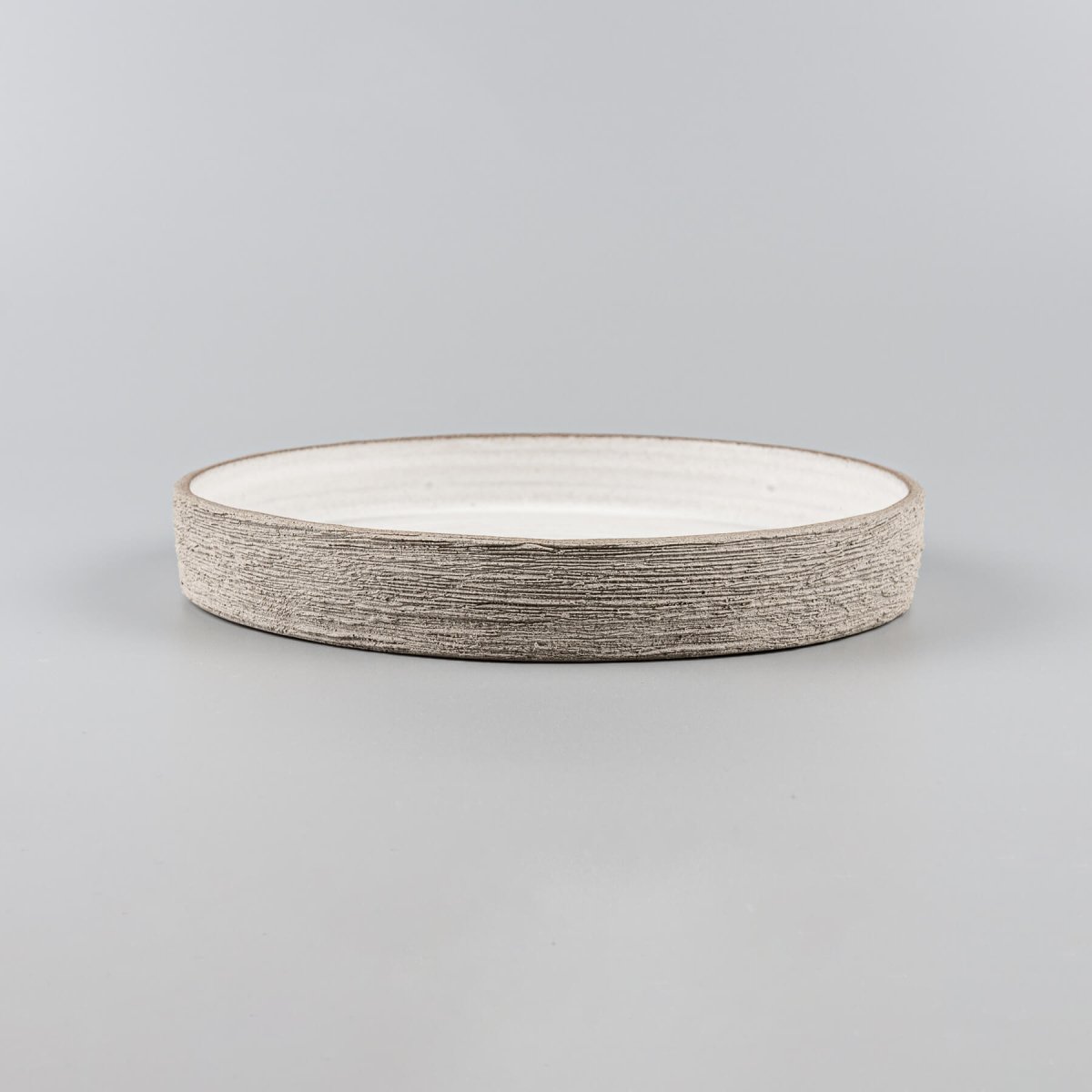Luxury stoneware plate with straight edges, flat base, and artisan-carved rim for premium culinary service.