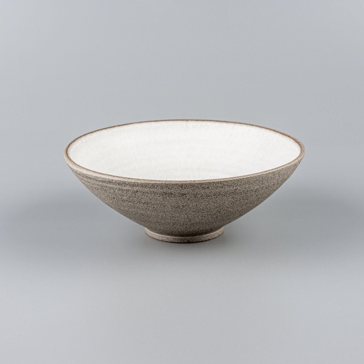 Side profile of artisan-crafted ceramic bowl with smooth lines and minimalist form.