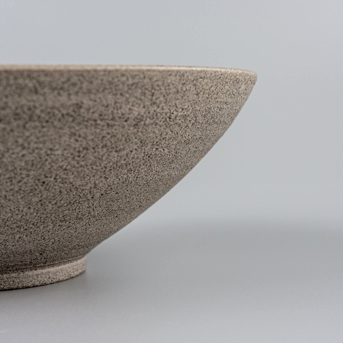 Textured dark stoneware exterior of artisan ceramic bowl for high-end kitchenware.