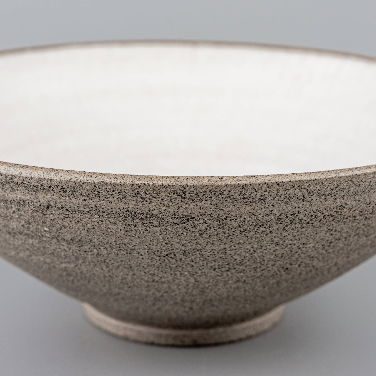 Base detail of handmade ceramic bowl with stable foot for elegant serving.