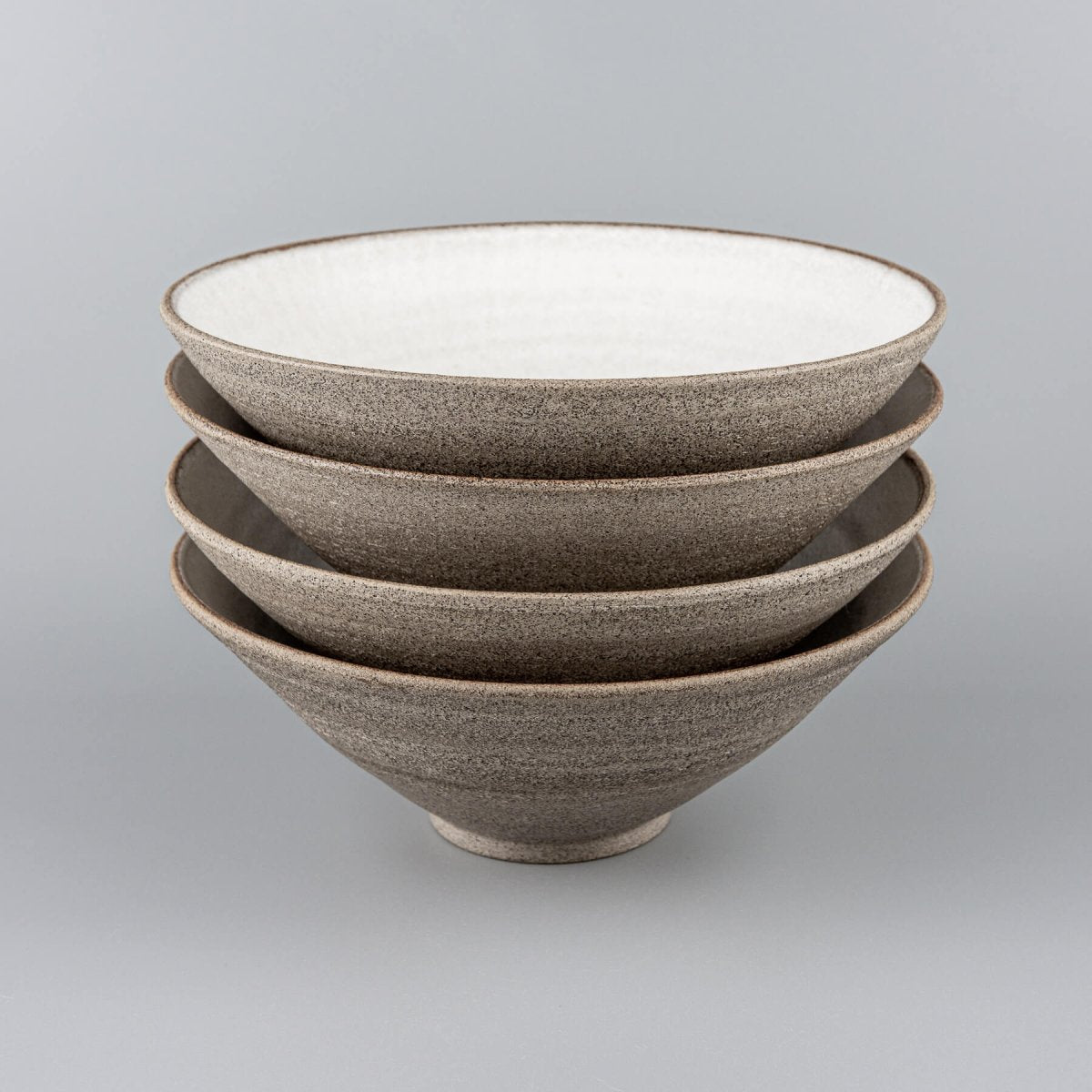 Stacked handmade ceramic bowls with matching design for restaurant use.