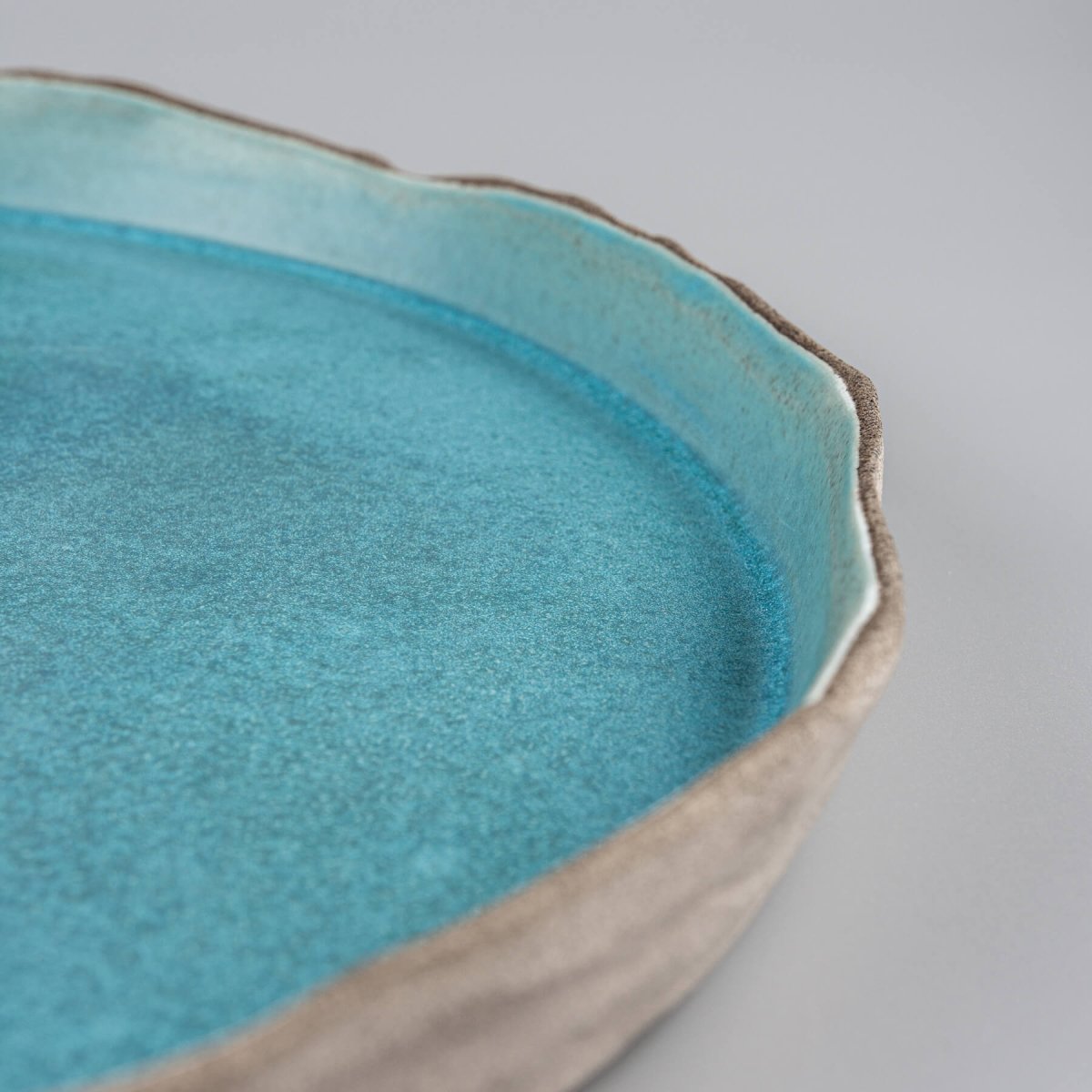 Elegant handmade dinner plate in turquoise glaze with flat base and refined craftsmanship.