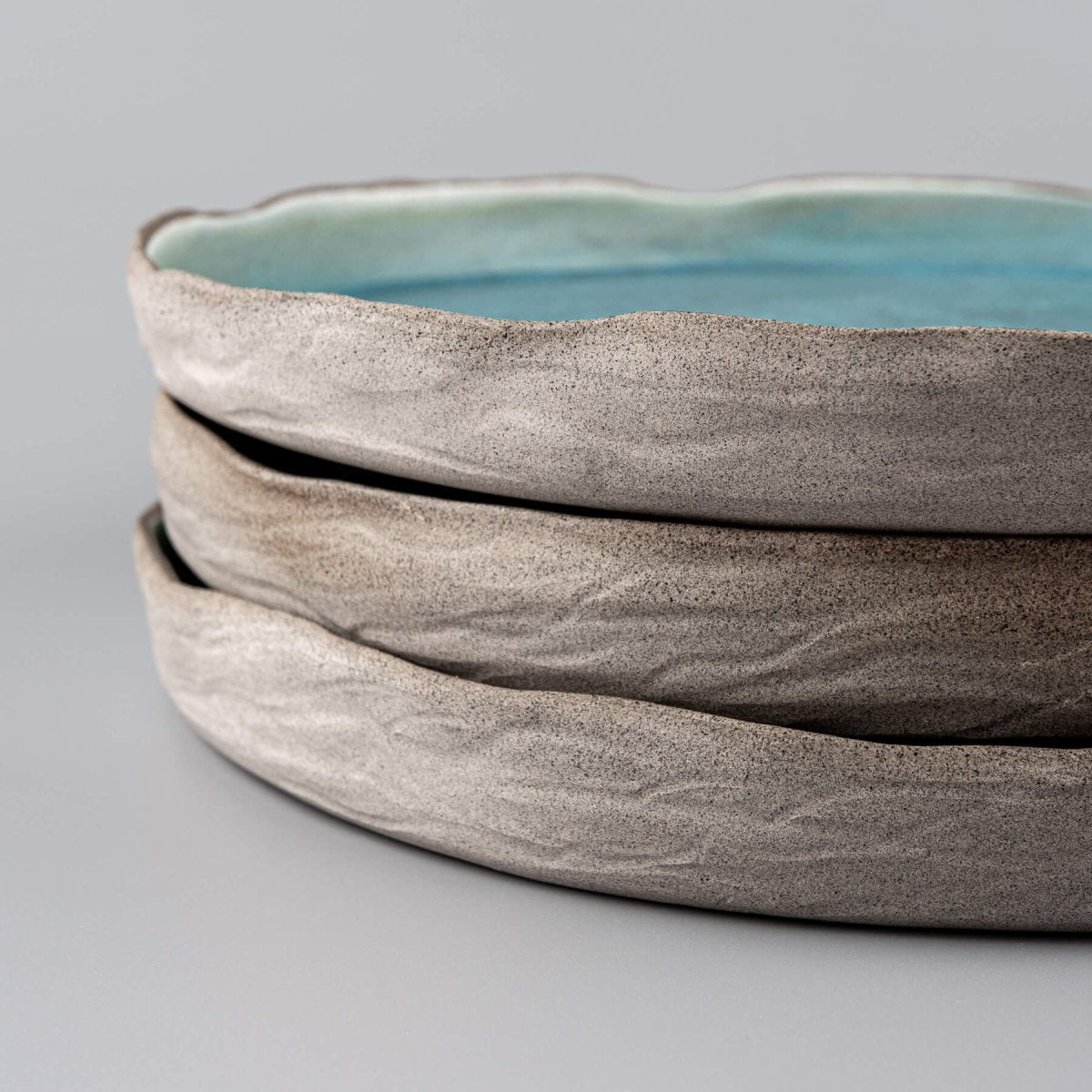 Set of handmade dinner plates in ocean-inspired turquoise for luxury tableware collections.