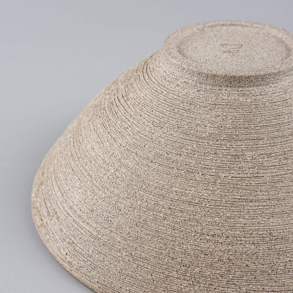 Texture focus on raw dark clay used for handmade serving bowls.