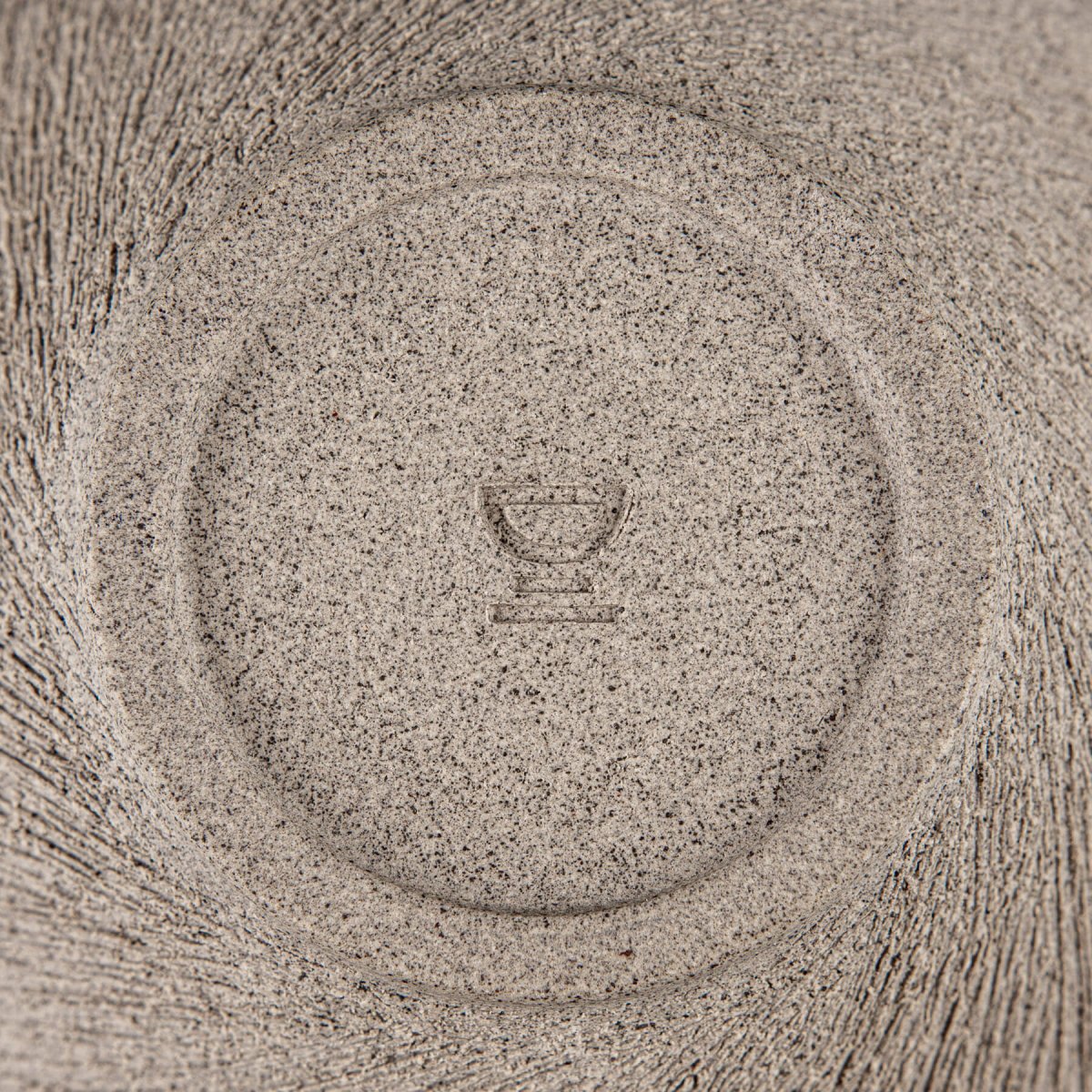 Bottom stamp and foot ring of handcrafted ceramic bowl with artisan detailing.