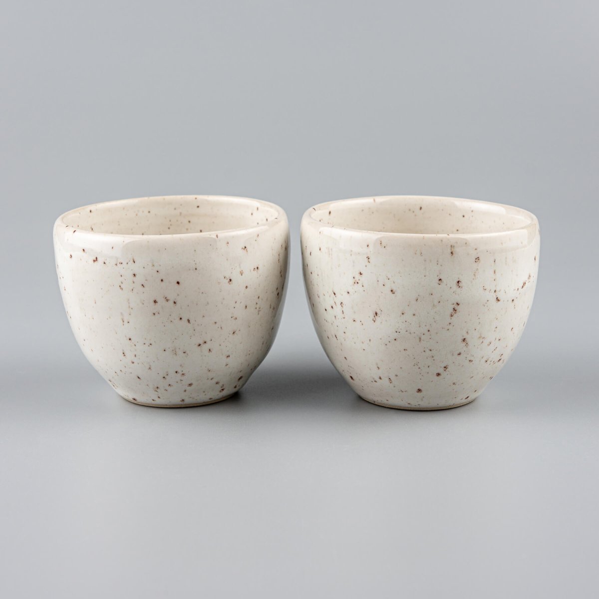 Rounded stoneware coffee cup with ivory glaze, ideal for espresso, tea, or artisanal kitchenware collections.
