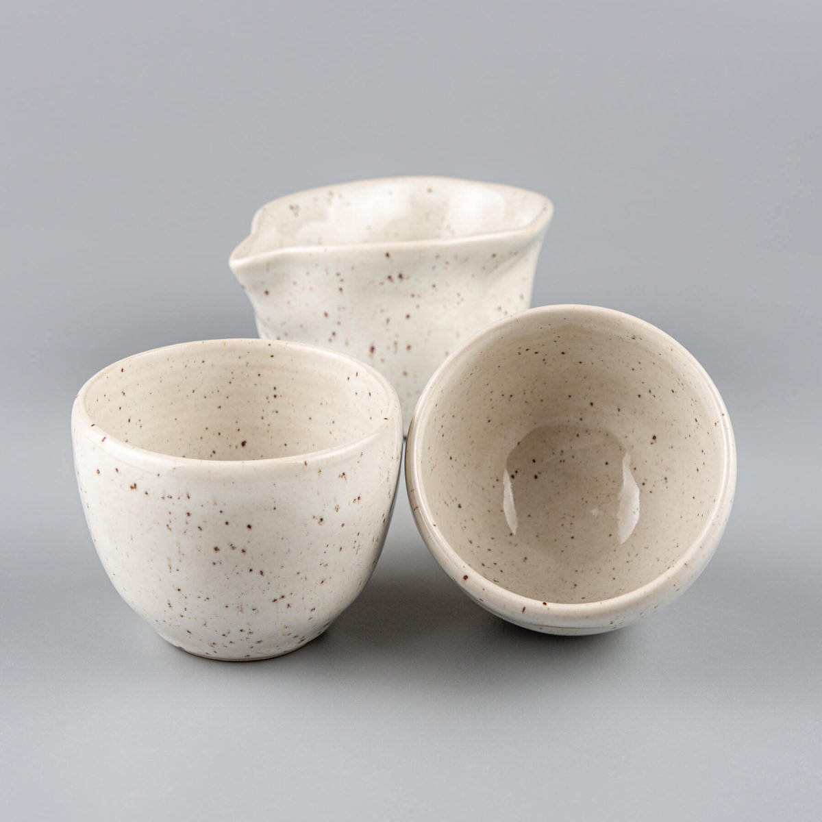 Handmade pottery set featuring coffee cups and a pitcher, crafted for fine dining and collectible tableware.