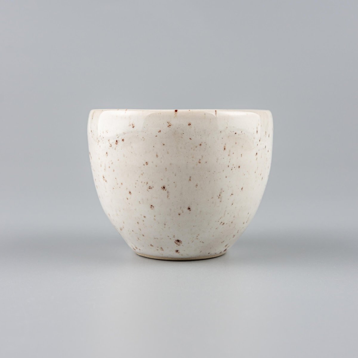 Elegant ivory-glazed stoneware coffee cup with natural speckle finish for boutique hotel tableware.