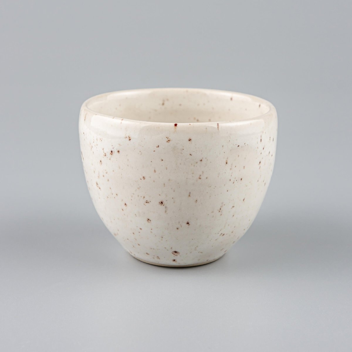Handcrafted ivory-glazed stoneware coffee cup with speckled finish, perfect for fine dining restaurants and boutique hotels.