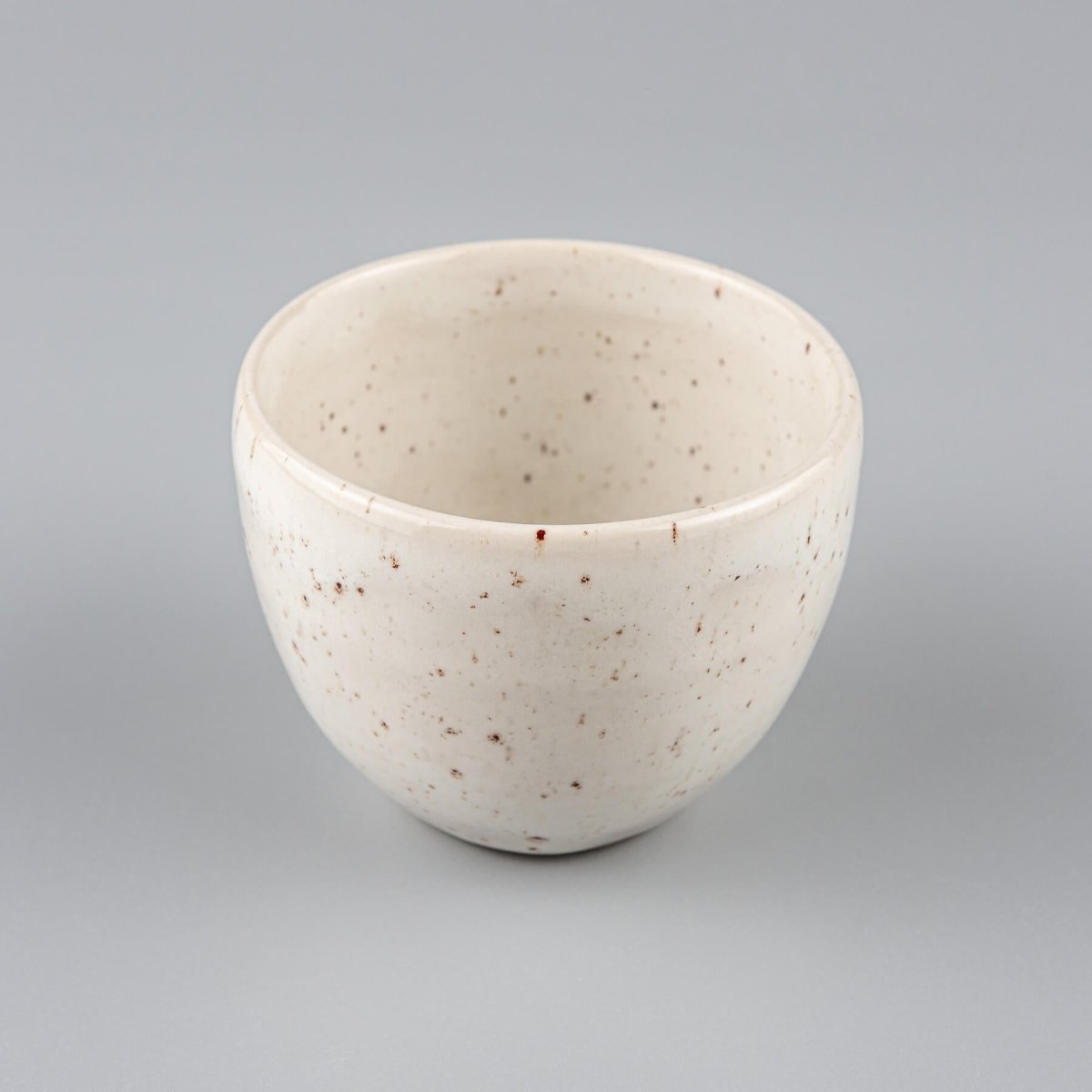 Minimalist stoneware coffee cup in ivory glaze with rounded shape, ideal for home kitchens, restaurants, and interior design.
