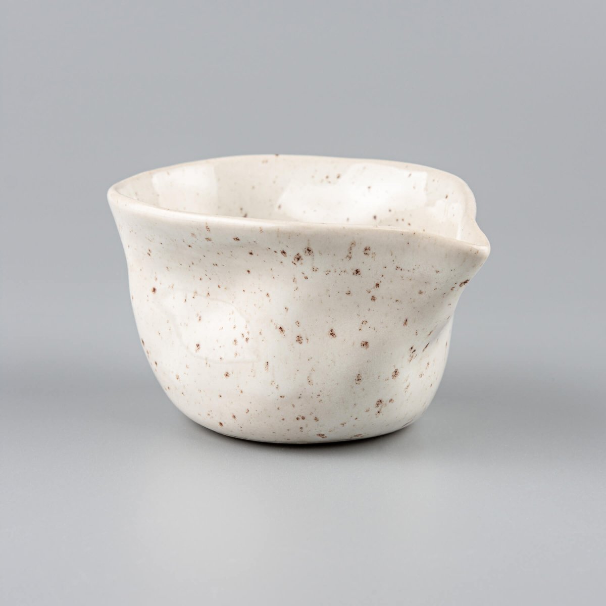 Organic-shaped milk pitcher in ivory-glazed stoneware, handmade for serving coffee and tea with elegance.