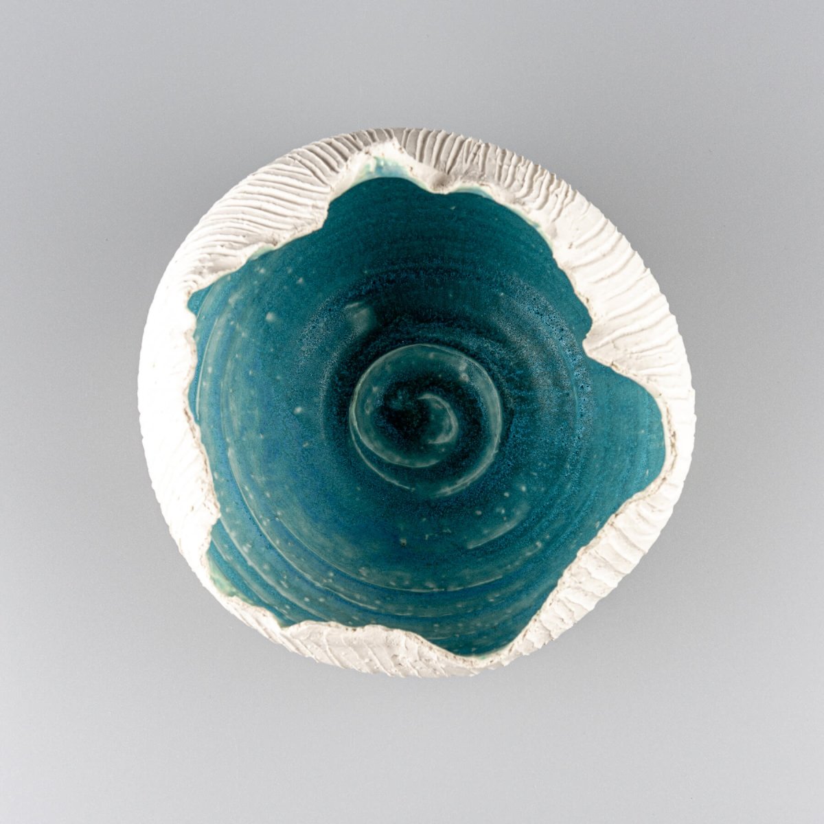 Limited-edition stoneware vase featuring an organic rim and ocean-inspired turquoise glaze, perfect for boutique hotels.