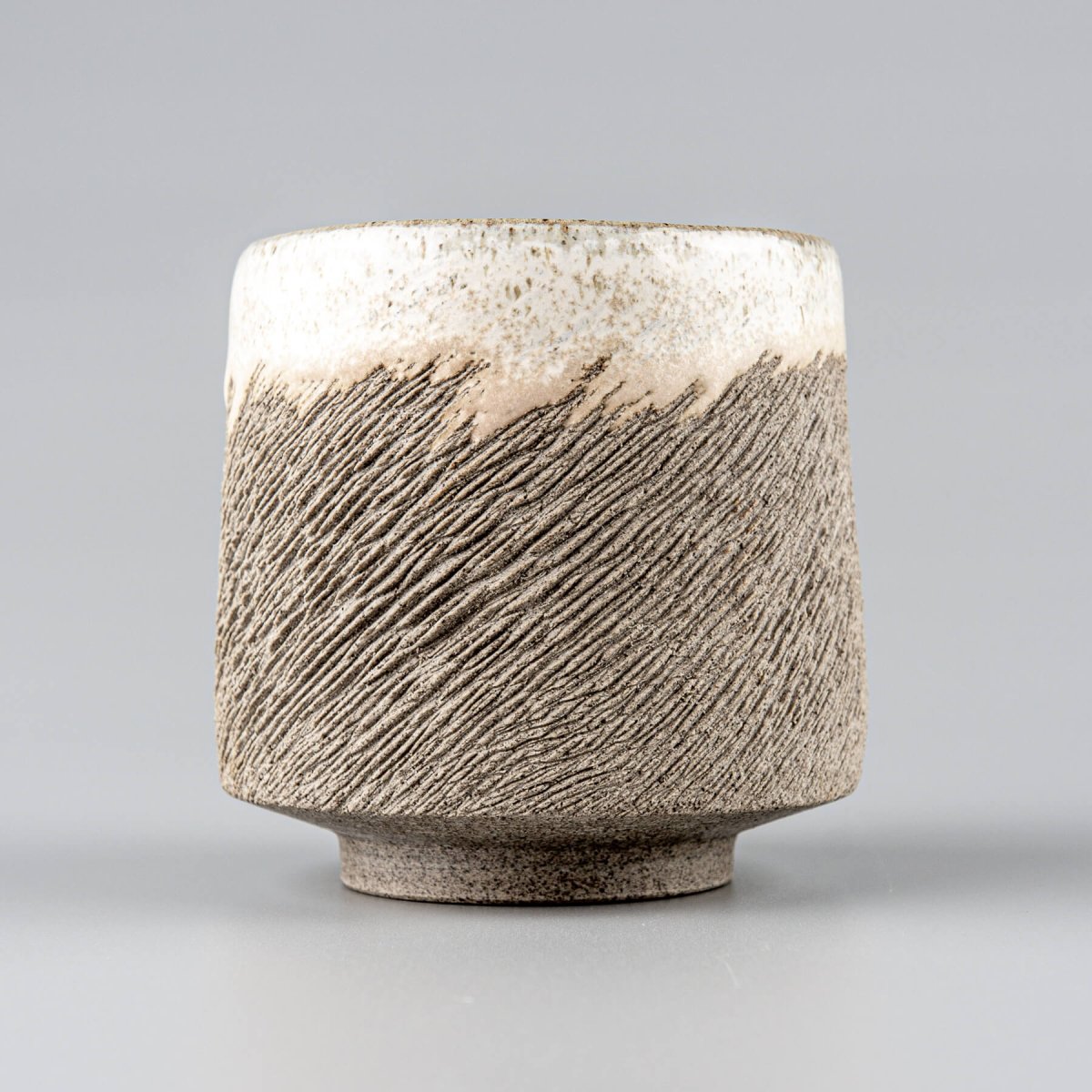 Handcrafted stoneware coffee cups with carved texture and semi-gloss white glaze, ideal for fine restaurants and hotel use.