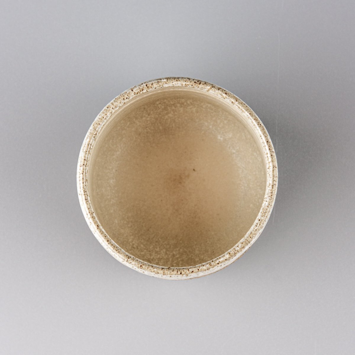 Top view of handmade stoneware coffee cup with smooth glazed interior, perfect for kitchenware and culinary presentation.