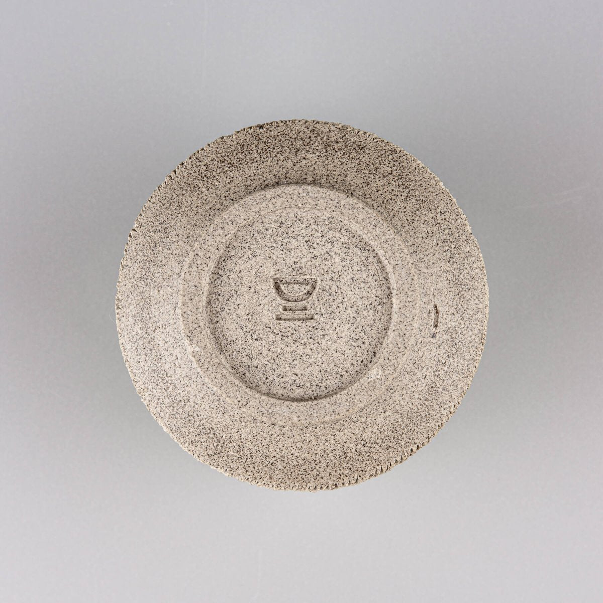 Bottom view of handcrafted stoneware coffee cup showing artist’s wheel-thrown finish.