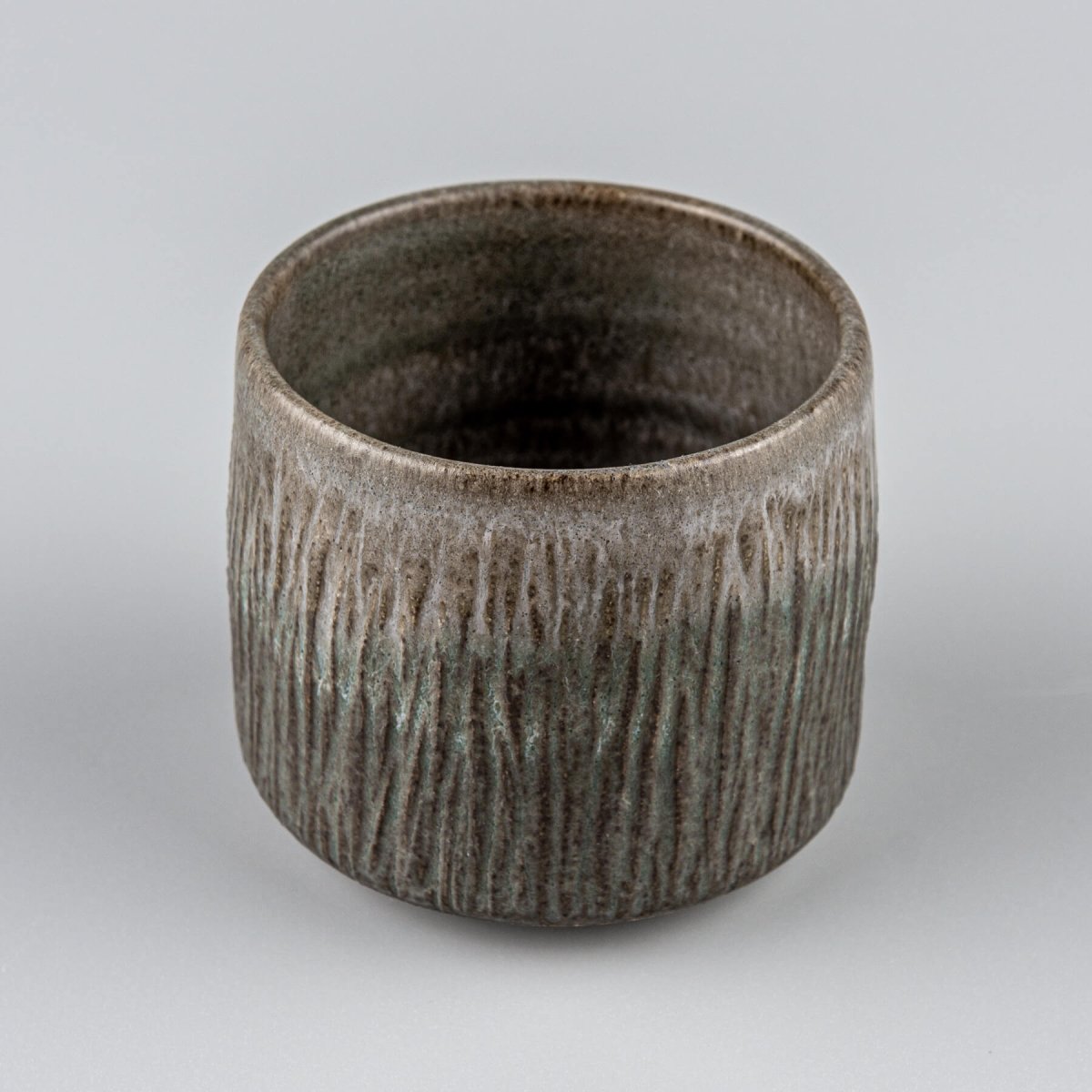 Unique handmade stoneware cup with raised base and modern design, collectible pottery for interior design.