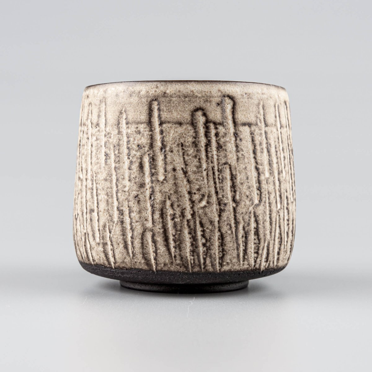 Handcrafted ceramic mugs with carved stoneware texture and matte white glaze, ideal for home and restaurant tableware.
