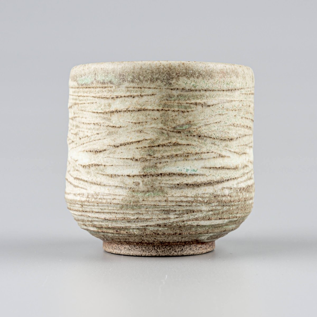 Handmade mugs with stoneware clay and carved texture for home and restaurant tableware.