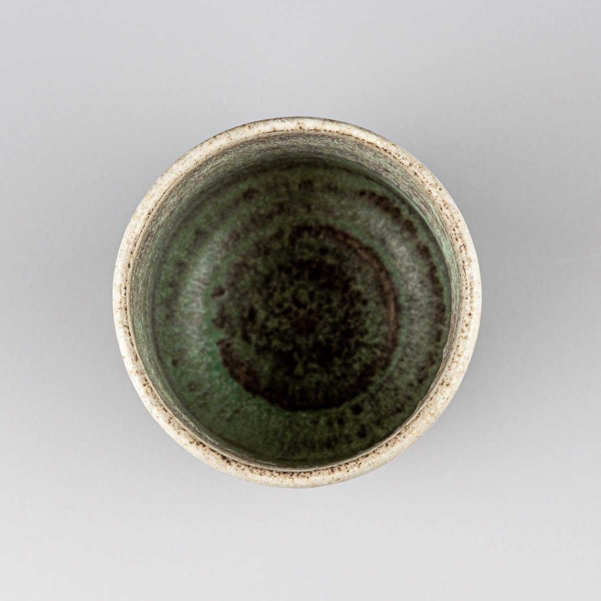 Top view of artisanal ceramic mug with textured glaze for coffee, tea, or matcha tea rituals.
