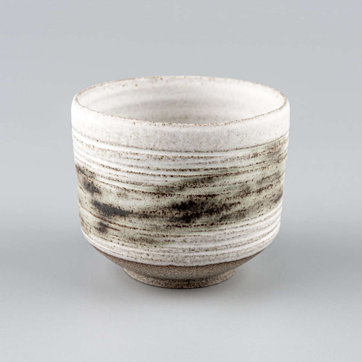 Artisan pottery mugs with rustic raw clay base and matte glaze finish.