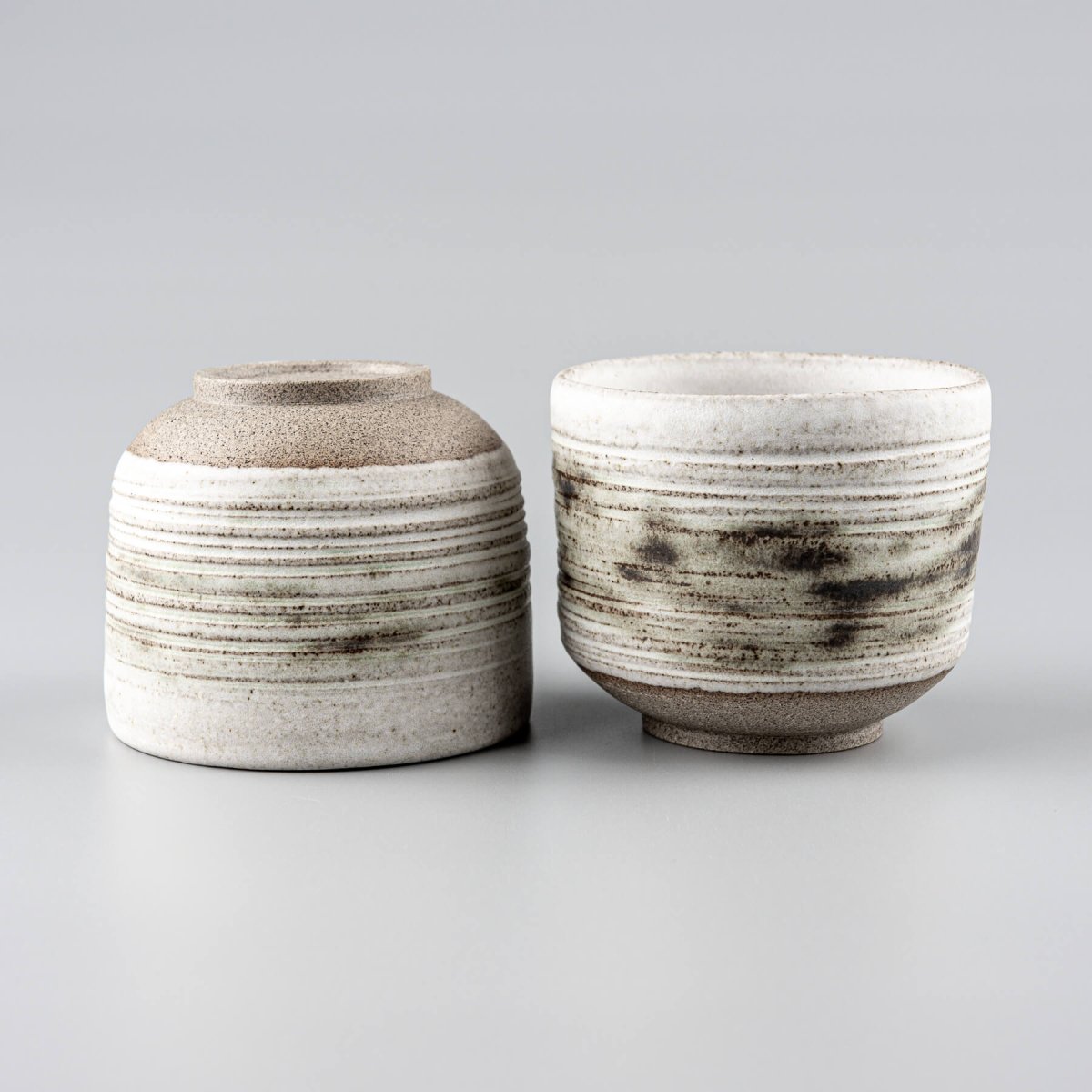 Unique stoneware mugs showcasing modern craftsmanship and carved detailing.