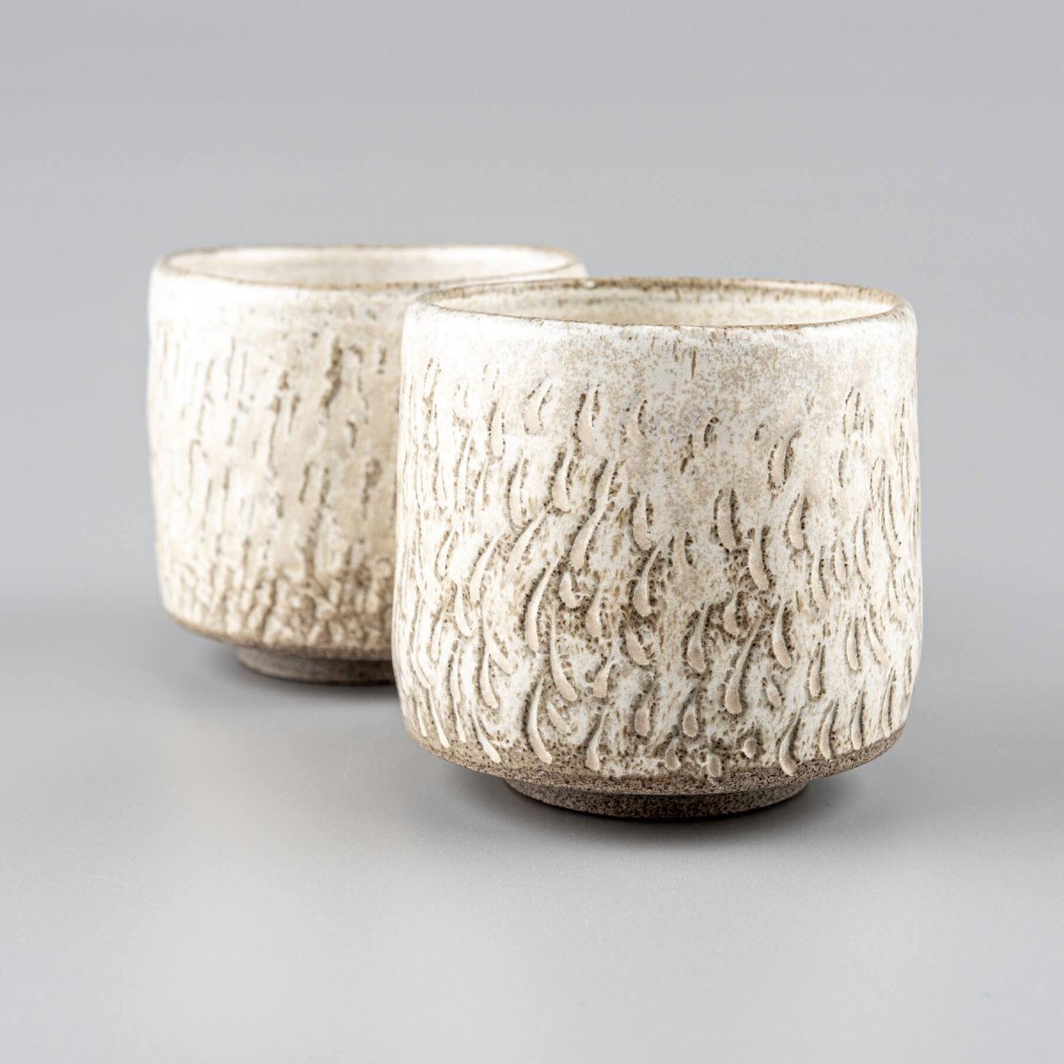 Handcrafted ceramic espresso cups set with carved texture and matte glaze for modern kitchenware.