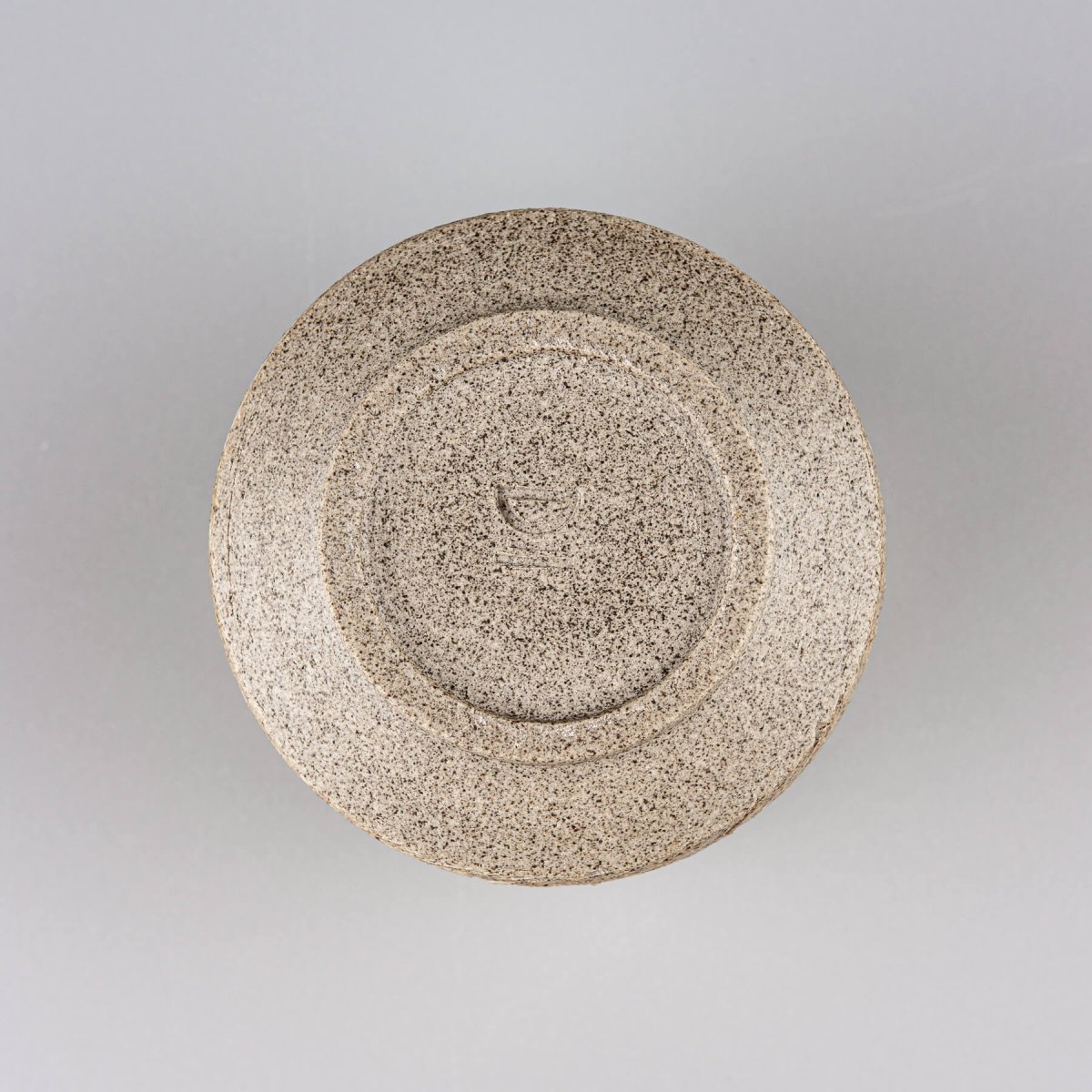 Handmade ceramic mug base with textured stoneware finish, durable collectible pottery for fine dining.